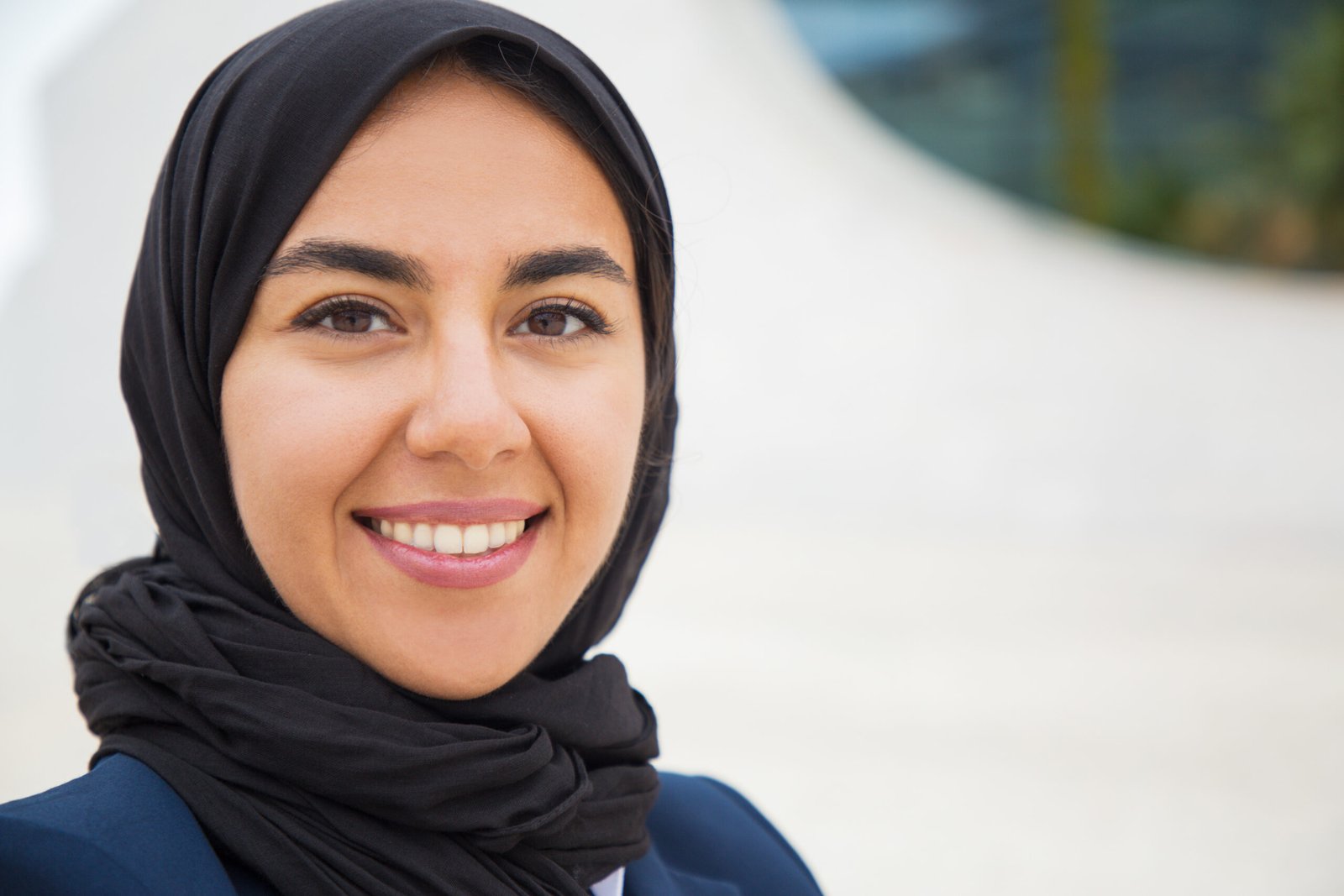 Happy confident muslim business lady posing outside scaled